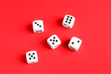Photo of Many white game dices on red background, flat lay