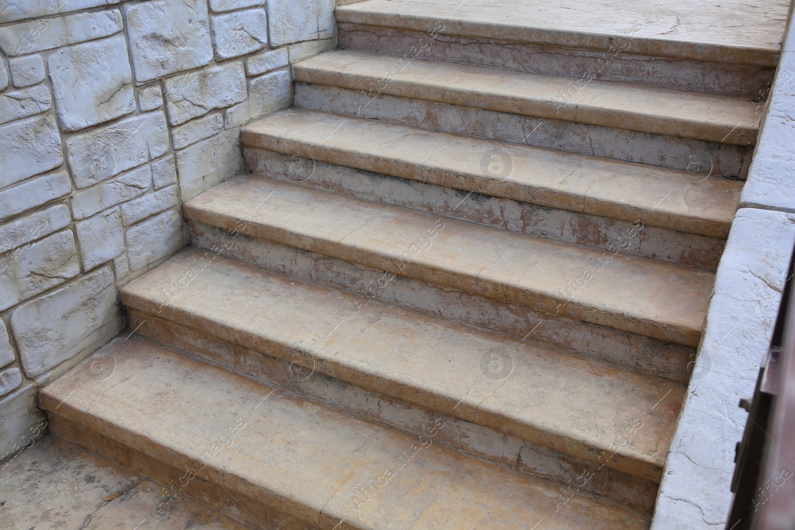 Photo of View of beautiful stone stairs near brick wall outdoors