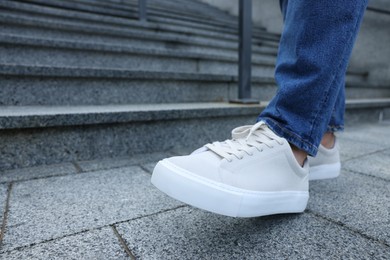 Photo of Man walking in stylish sneakers outdoors, closeup. Space for text