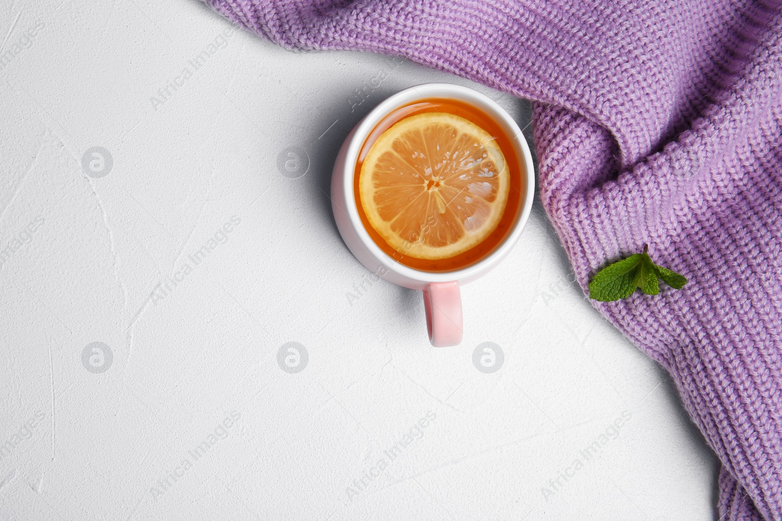 Photo of Cup with hot tea and lemon on light background, top view. Space for text