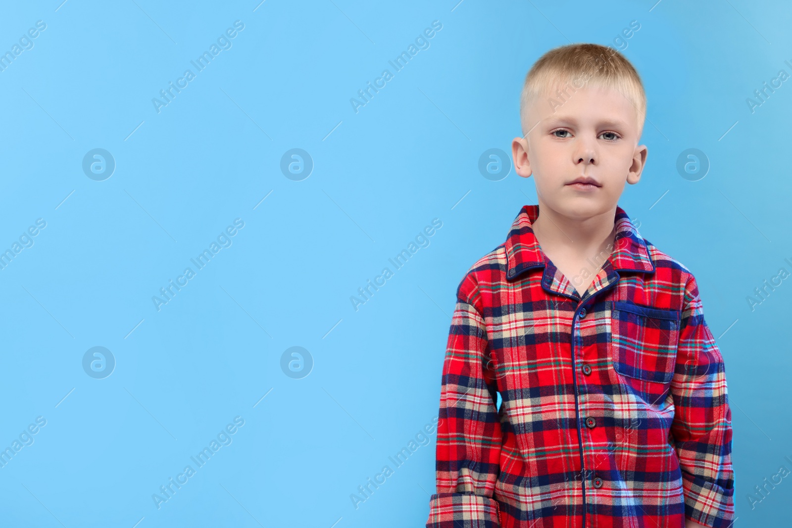 Photo of Sleepy boy on light blue background, space for text. Insomnia problem