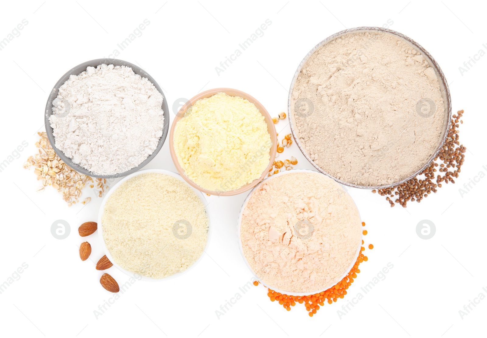 Photo of Different types of flour in bowls on white background, top view