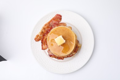 Delicious pancakes with bacon, butter and honey isolated on white, top view