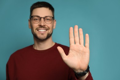 Photo of Left-handed man against light blue background, focus on palm