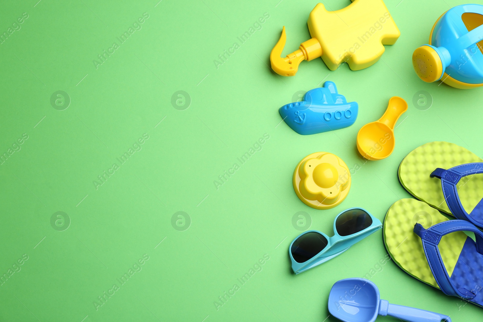 Photo of Flat lay composition with bright beach toys on color background. Space for text