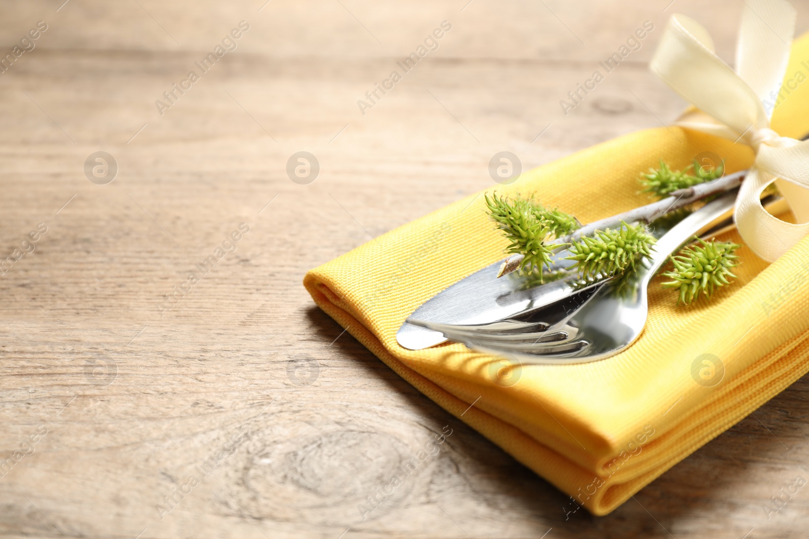 Photo of Cutlery set on wooden table, closeup view with space for text. Easter celebration