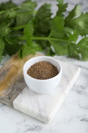 Photo of Bowl of celery seeds on white marble table