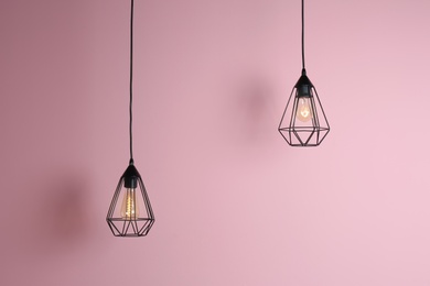 Photo of Modern hanging lamp on color background. Idea for interior design