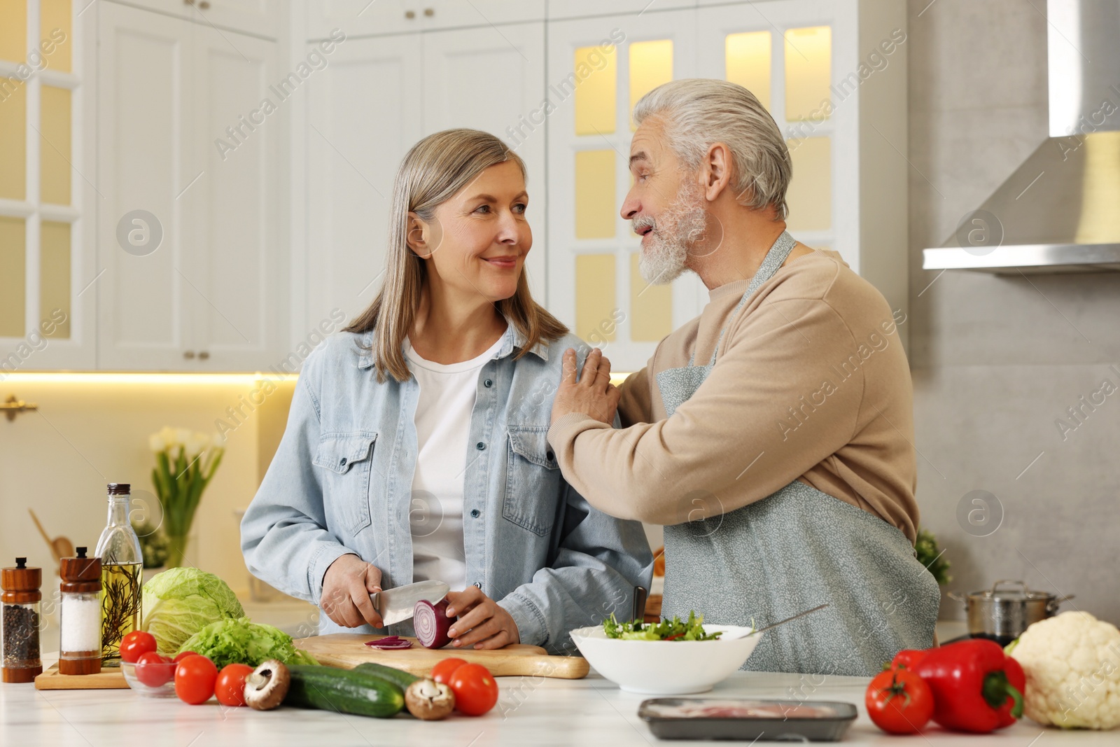 Photo of Happy senior couple cooking together in kitchen