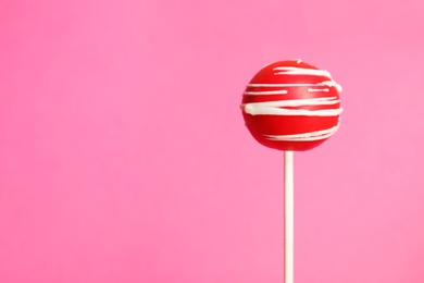 Photo of Bright delicious cake pop on color background. Space for text