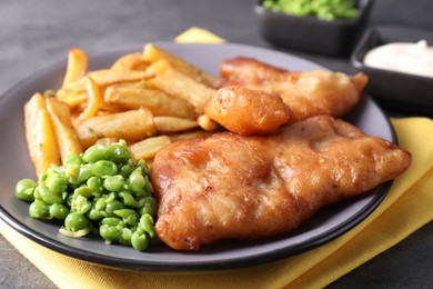 Photo of Tasty fish, chips and peas on table, closeup