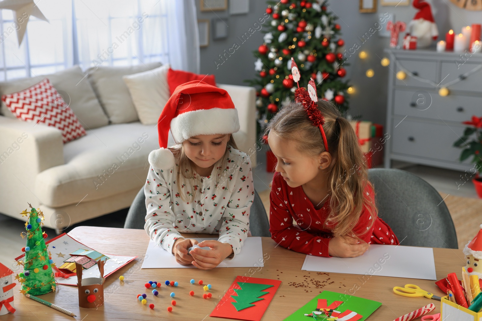 Photo of Cute little children making beautiful Christmas greeting cards at home