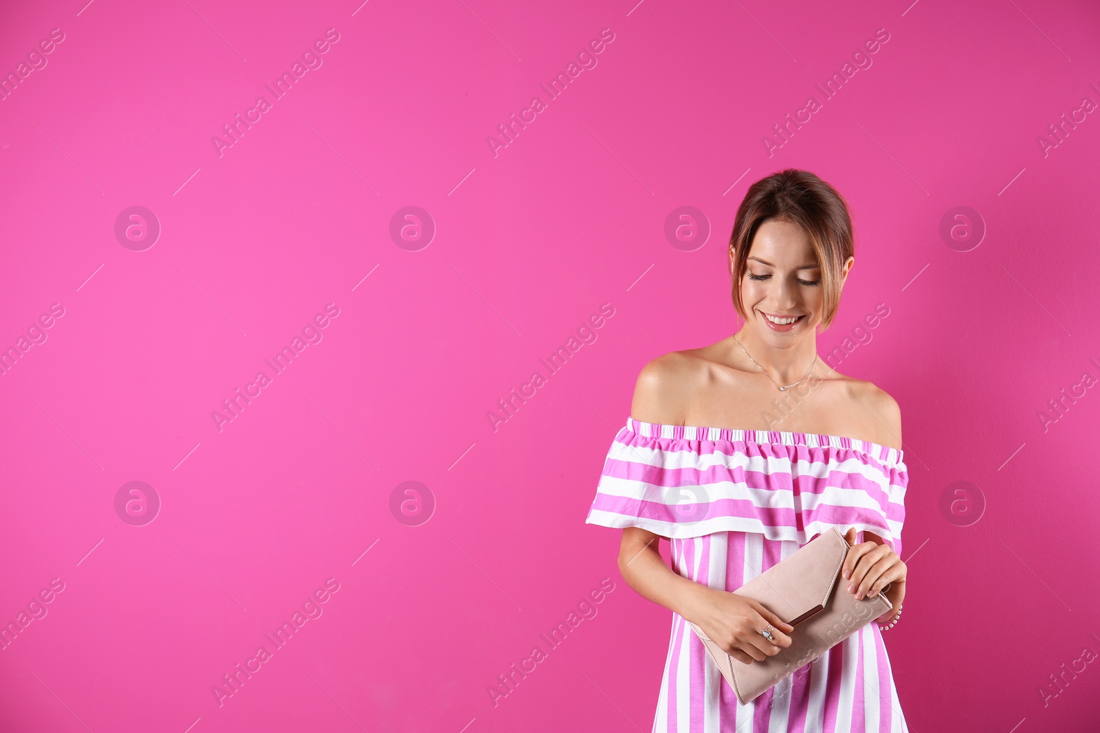 Photo of Portrait of young woman in stylish outfit with purse on color background, space for text