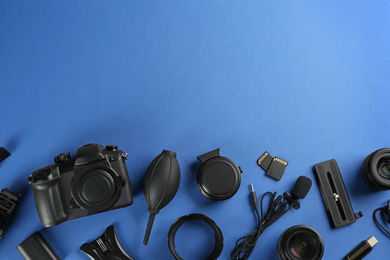 Flat lay composition with camera and video production equipment on blue background, space for text