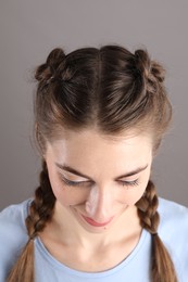 Woman with braided hair on grey background