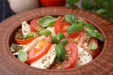 Photo of Delicious Caprese salad with pesto sauce in plate, closeup
