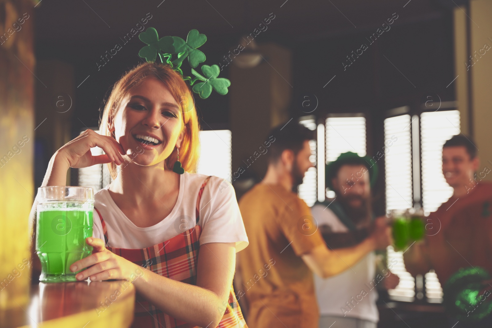 Photo of Young woman with glass of green beer in pub, space for text. St. Patrick's Day celebration