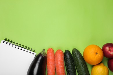 Photo of Notebook, fresh fruits and vegetables on light green background, flat lay with space for text. Low glycemic index diet