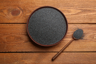 Photo of Poppy seeds in spoon and bowl on wooden table, flat lay