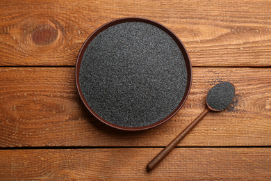 Poppy seeds in spoon and bowl on wooden table, flat lay