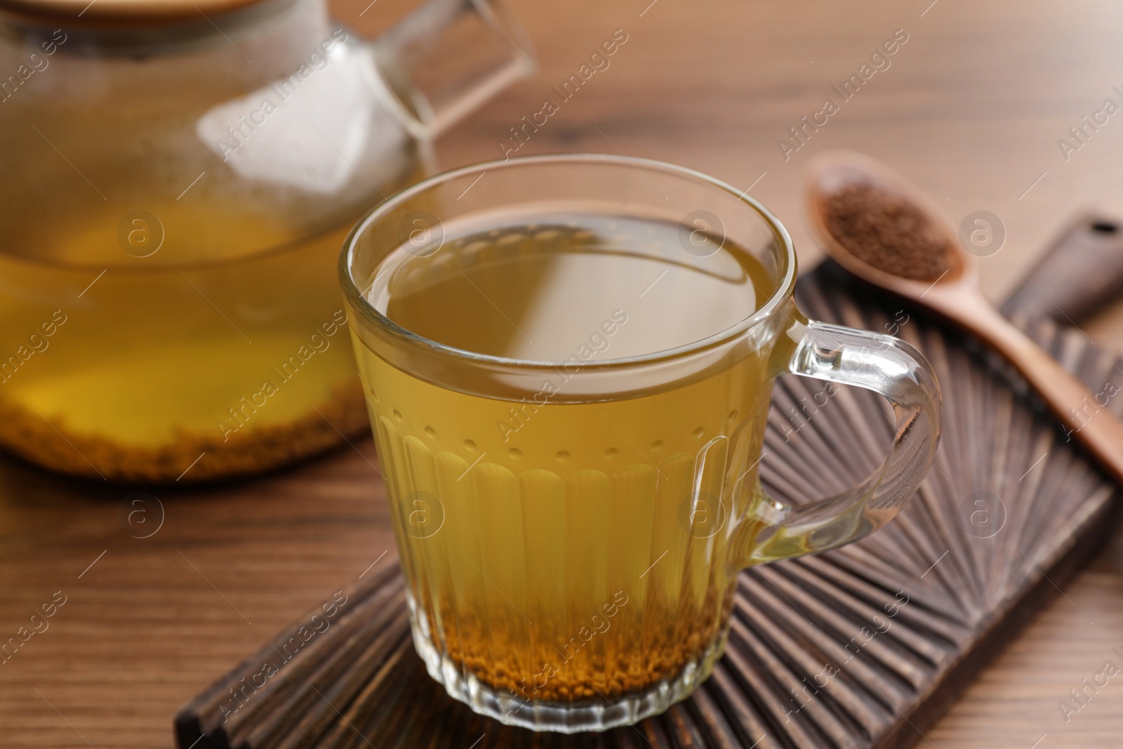 Photo of Cup of aromatic buckwheat tea and granules on wooden table