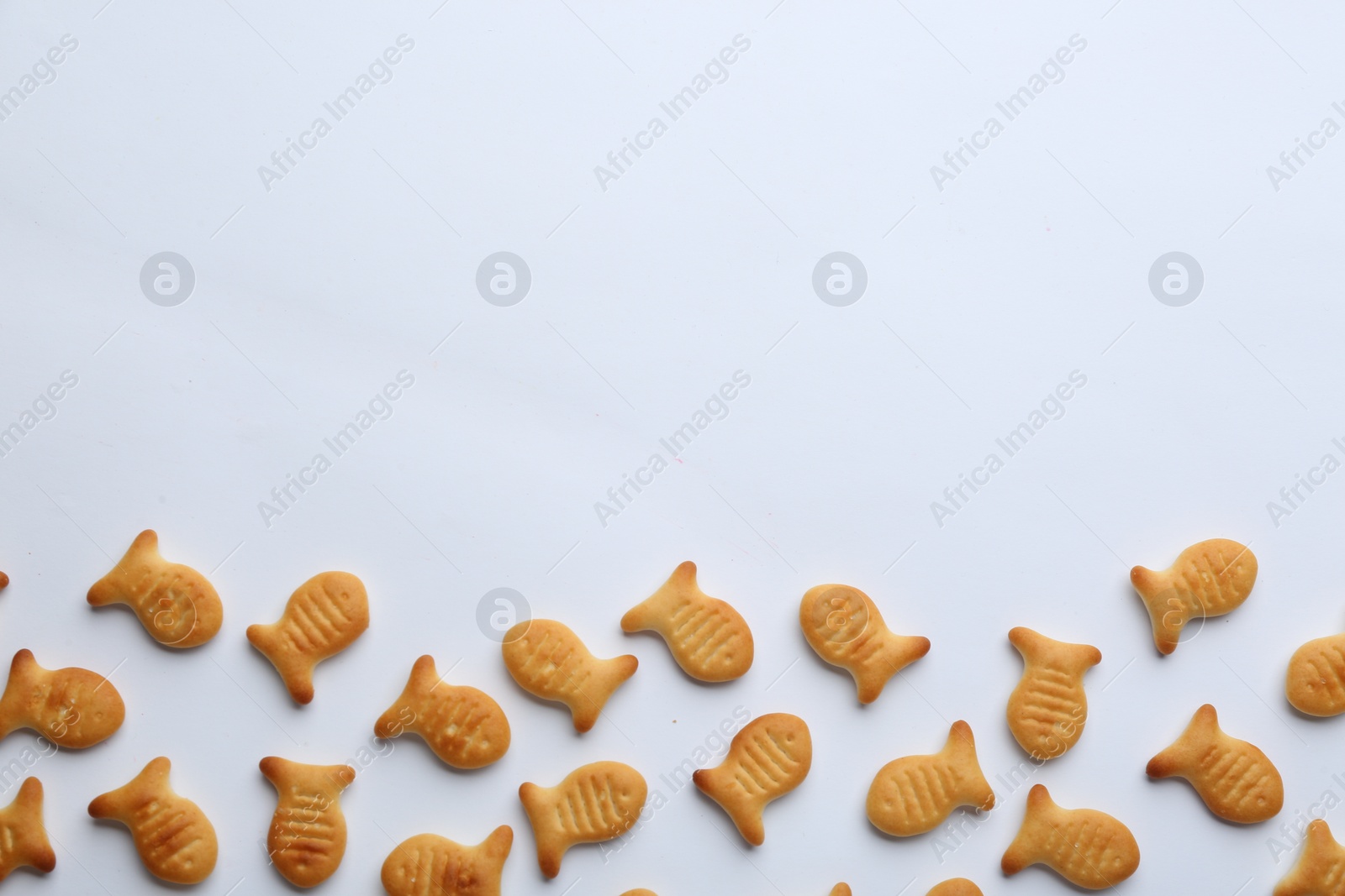 Photo of Delicious goldfish crackers on white background, top view