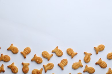 Delicious goldfish crackers on white background, top view