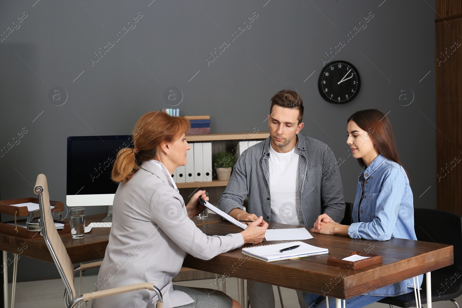 Photo of Lawyer having meeting with young couple in office