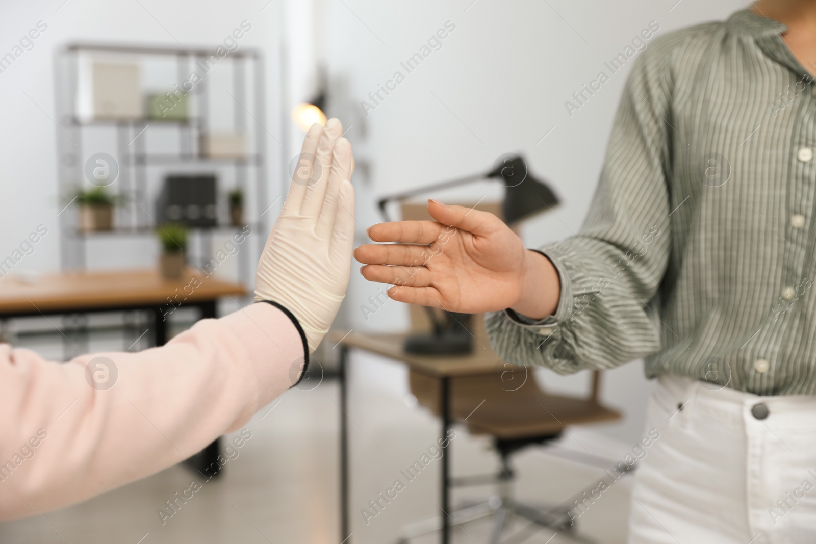 Photo of Woman refusing handshake from coworker in office, closeup