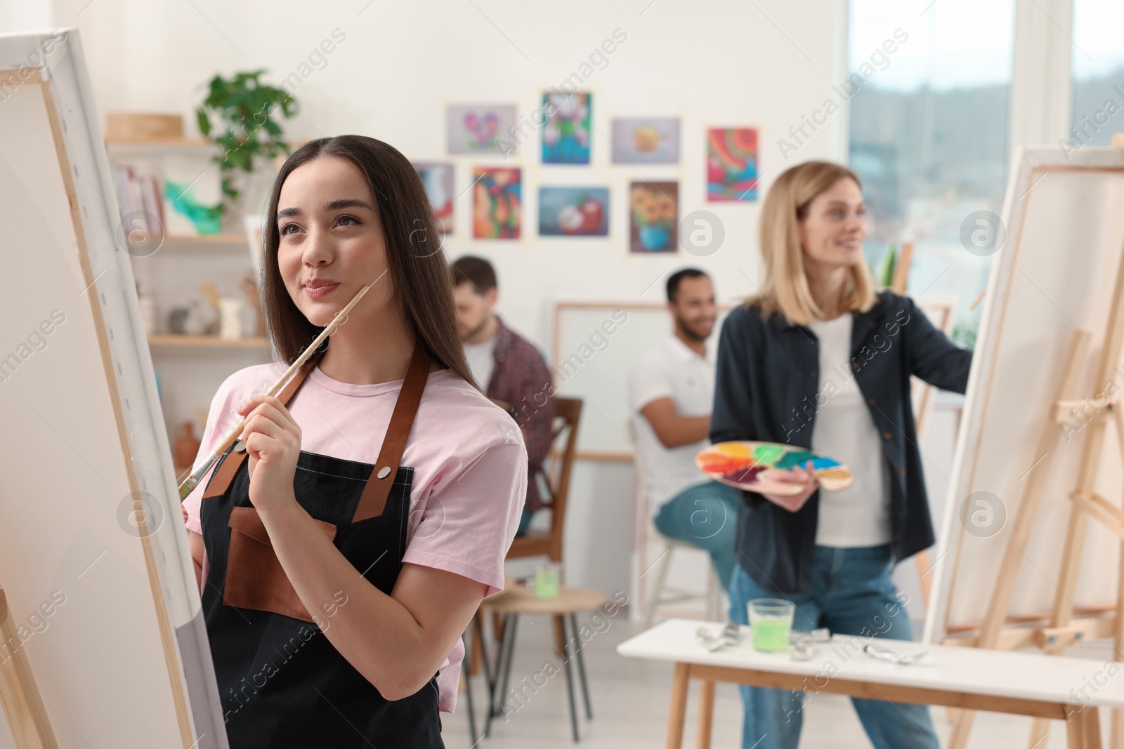 Photo of Group of students attending painting class in studio. Creative hobby