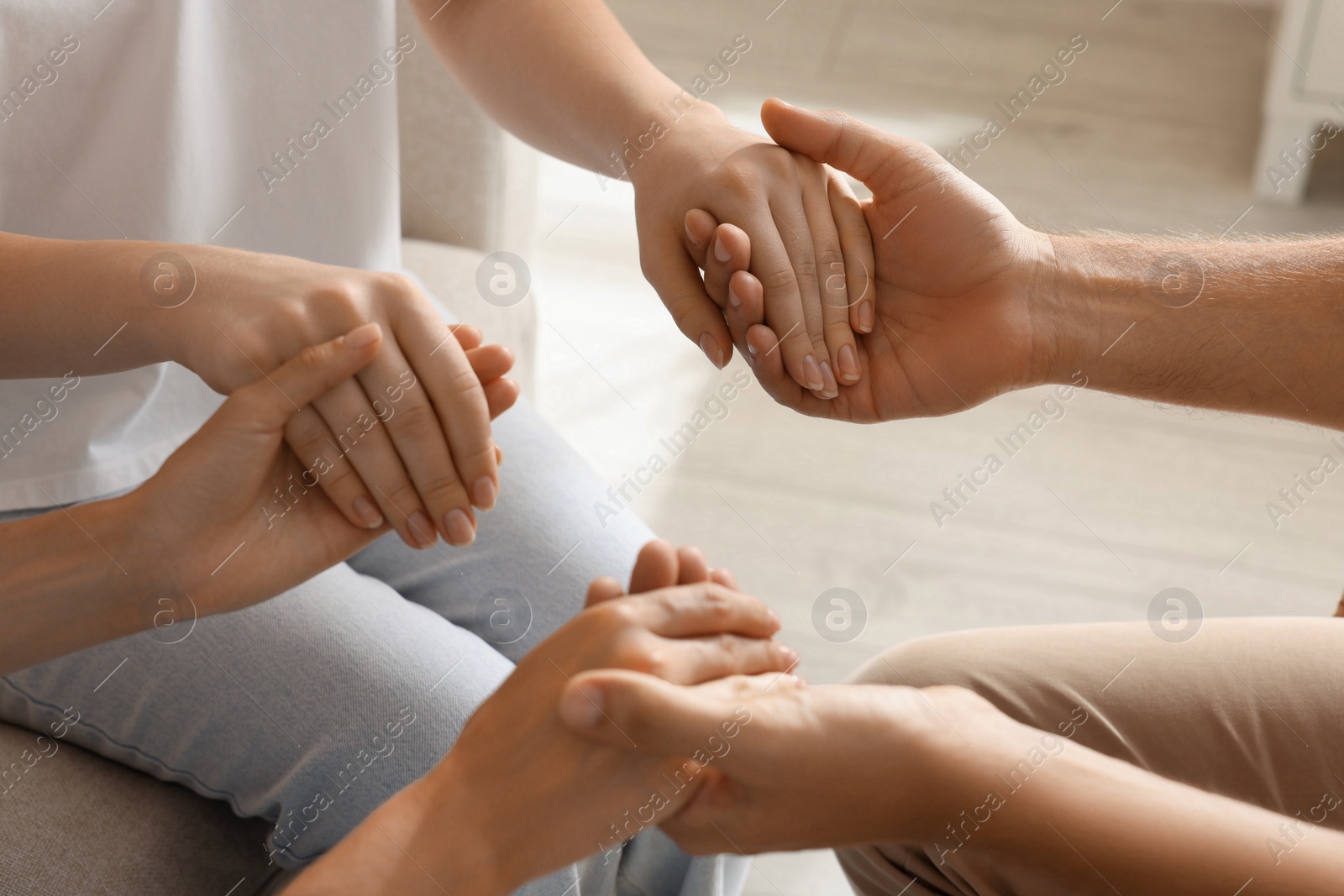 Photo of Group of religious people holding hands and praying together indoors, closeup