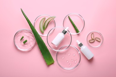 Photo of Flat lay composition with aloe vera leaves and cosmetic products on pink background