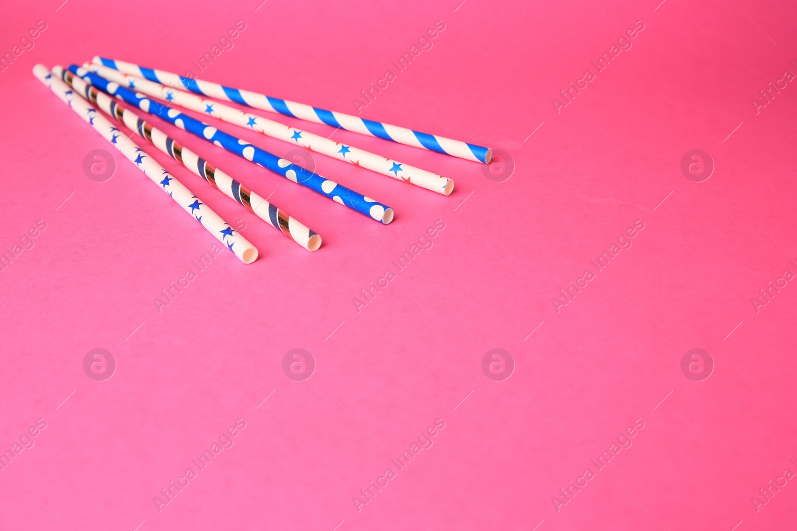 Photo of Colorful paper drinking straws on pink background. Space for text