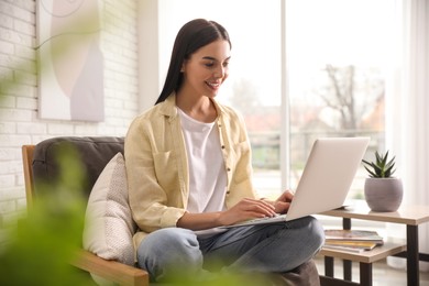 Photo of Beautiful young woman using laptop at home