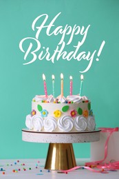 Happy Birthday! Delicious cake and party decor on white wooden table against turquoise background
