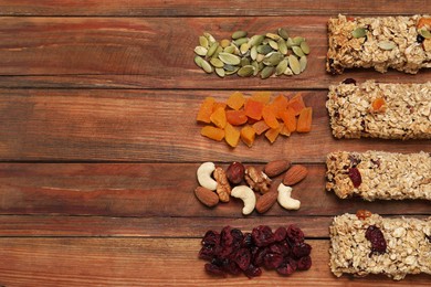 Photo of Different tasty granola bars and ingredients on wooden table, flat lay. Space for text