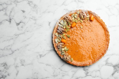 Photo of Delicious fresh homemade pumpkin pie on white marble table, top view. Space for text