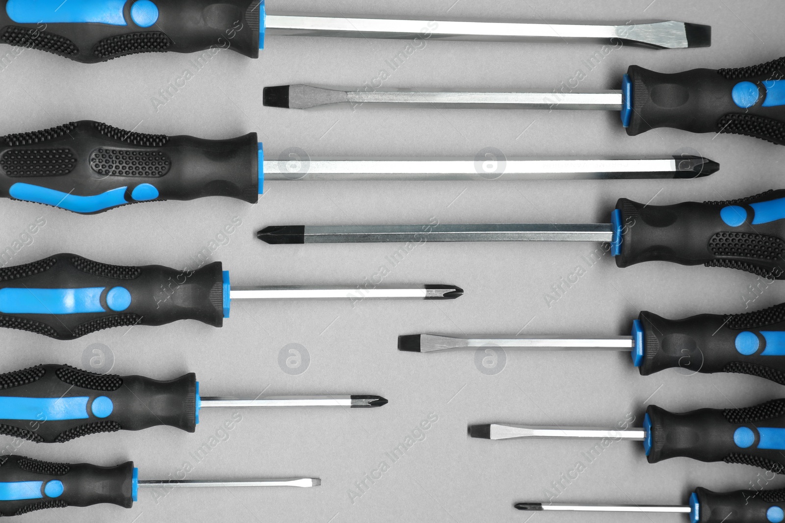 Photo of Set of screwdrivers on grey background, flat lay