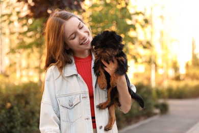 Photo of Young woman with adorable Brussels Griffon dog in park