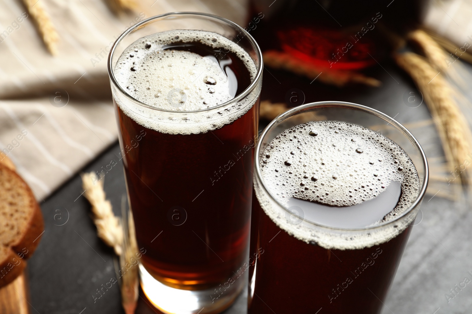 Photo of Glasses of delicious kvass on black table, closeup