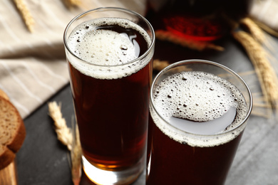 Glasses of delicious kvass on black table, closeup