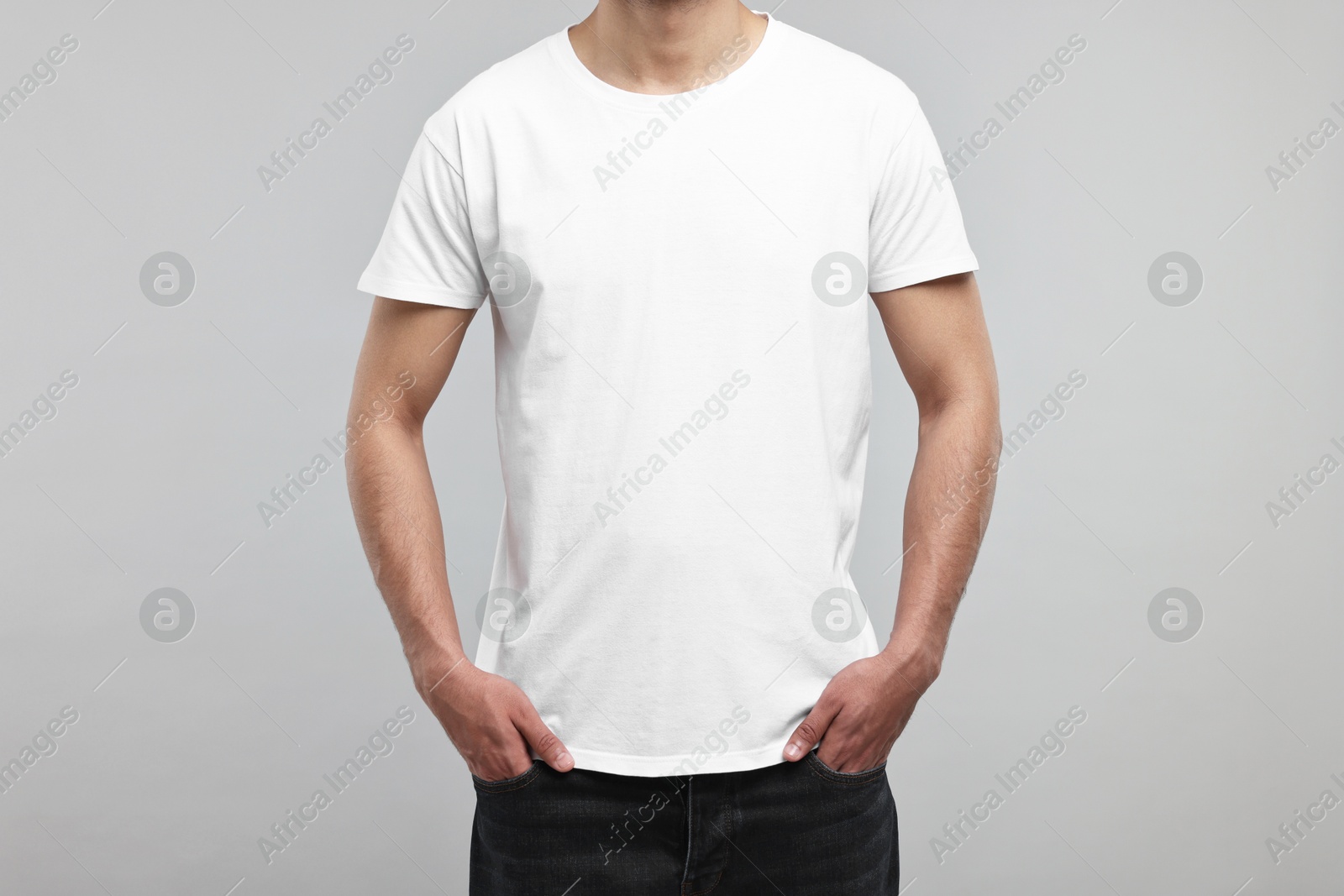 Photo of Man in white t-shirt on grey background, closeup