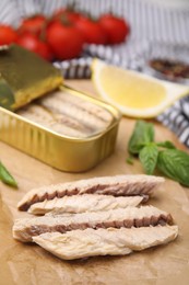 Photo of Canned mackerel fillets served on parchment, closeup