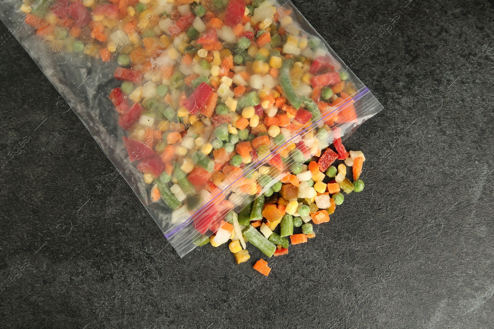 Photo of Zip bag with different frozen vegetables on grey table, top view