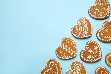 Tasty heart shaped gingerbread cookies on light blue background, flat lay. Space for text