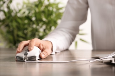 Photo of Woman using computer mouse with laptop at table, closeup