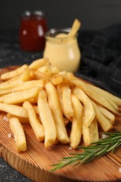 Delicious french fries with rosemary on grey table, closeup