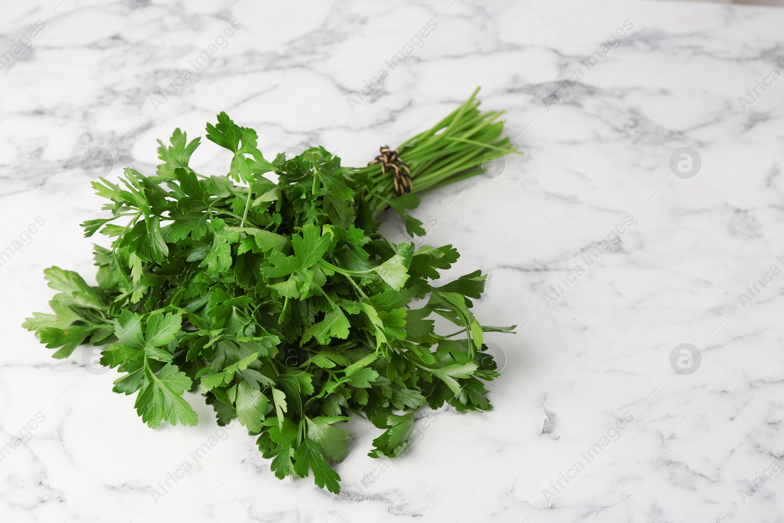 Photo of Bunch of fresh green parsley on marble background
