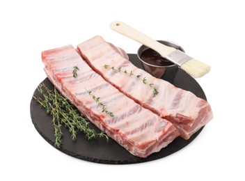 Photo of Raw pork ribs, thyme and sauce isolated on white