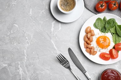 Photo of Tasty breakfast with fried egg, beans and coffee served on grey marble table, flat lay. Space for text